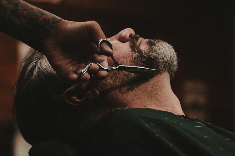 Mann bekommt einen Haarschnitt und eine Rasur in einem Barbershop.