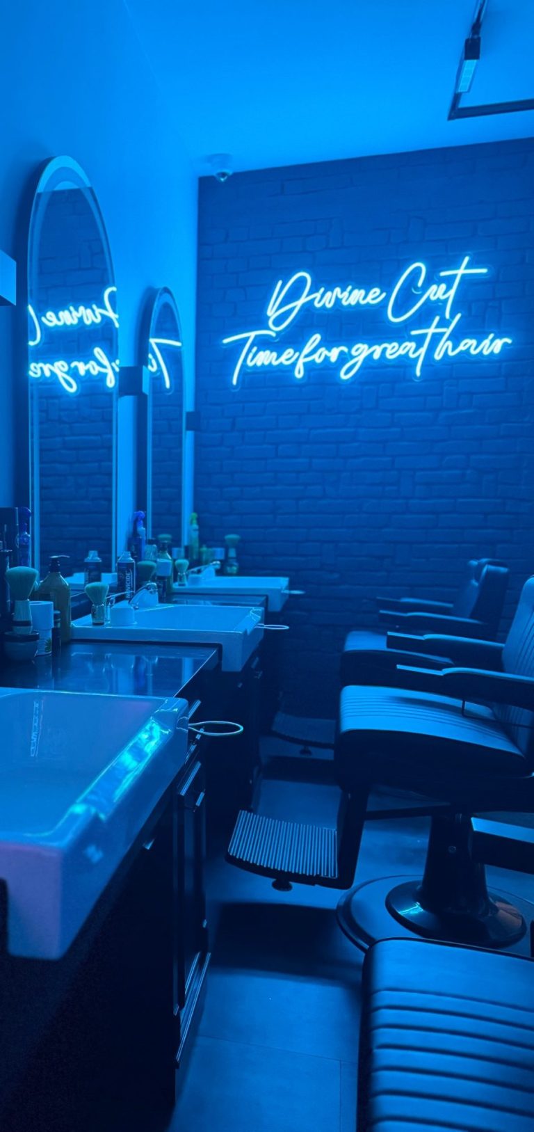 Friseur mit blauen Lichtern, Spiegeln und einem Neon-Schild mit dem Text "Time for great hair".